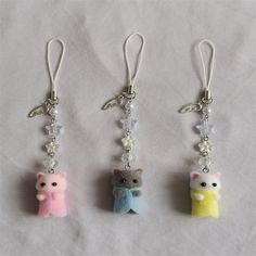 three small key chains with charms attached to them