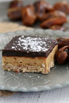 a piece of dessert sitting on top of a plate next to nuts and other food