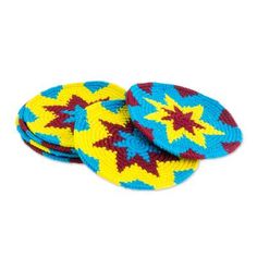 two knitted coasters with stars on them, one blue and the other yellow