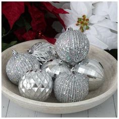 silver christmas ornaments in a bowl on a table