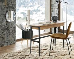 a wooden table sitting on top of a white rug next to a chair and window