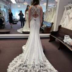 a woman is looking at her wedding dress in the mirror