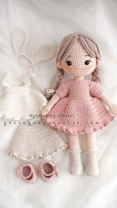 a crocheted doll and dress on a white sheet