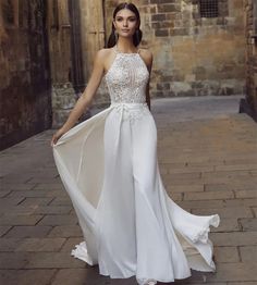 a woman in a white dress is posing for the camera