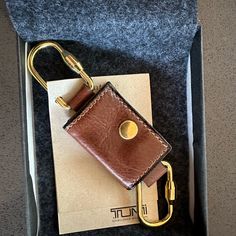 a brown leather keychain sitting in a box