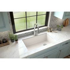 a white kitchen sink sitting under a window