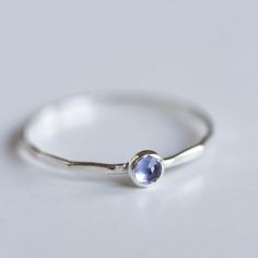 Tiny skinny stackable ring with beautiful Tanzanite stone. Its blue color with a shade of purple is fascinating.The ring is made with a skinny band, which allows you to create mind-blowing stacking sets! The ring is 0,8-0,9 mm thick and looks very dainty on the finger. Choose the cut of the stone (smooth or rose cut) and material for the ring (sterling silver or 9k gold).If you want to change the ring band design or get a custom ring or ring sets, feel free to contact me.You can order a ring of Dainty Everyday Crystal Ring With Birthstone, Dainty Crystal Birthstone Ring For Everyday, Dainty Everyday Crystal Birthstone Ring, Sterling Silver Stackable Rings With Gemstone, Dainty Stackable Sapphire Ring Gift, Dainty Stackable Rings With Gemstone In Round Band, Everyday Sterling Silver Birthstone Ring, Dainty Sterling Silver Midi Rings With Birthstone, Simple Sterling Silver Stackable Birthstone Rings