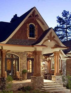 a house with stone and wood trim around the front door, porch and entry way