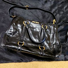 Miu Miu Black Vitello Shine Patent Leather Tote Bag Only Used Twice. Like New. Adjustable Strap Color: Black Material: Patent Leather Size: Approximate 13 X 6 X 9.5 Inch Made In Italy Black Top Handle Miu Miu Shoulder Bag, Black Miu Miu Shoulder Bag With Top Handle, Black Miu Miu Top Handle Shoulder Bag, Miu Miu Leather Evening Shoulder Bag, Miu Miu Formal Shoulder Bag With Gold-tone Hardware, Miu Miu Black Shoulder Bag For Everyday Use, Formal Miu Miu Shoulder Bag With Gold-tone Hardware, Luxury Black Miu Miu Shoulder Bag, Chic Black Miu Miu Shoulder Bag