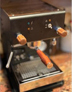 an espresso machine with two wooden handles