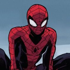 a spider - man sitting on the ground with his eyes wide open in front of him