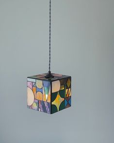 a multicolored light hanging from a ceiling fixture with a chain attached to it