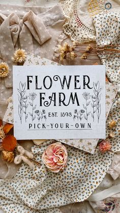 a flower farm sign surrounded by fabric and flowers