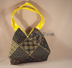 a black and yellow handbag on display against a wall