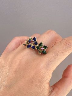 ♥ 14K Gold Vintage Ring with Three Blue Green Enamel Flowers with Ruby Center 7.11g R6734♥ The item measures 13.4mm in length (North South direction), 26mm in width (East West direction), and stands 7.3mm tall from the finger. Band width is 4mm. ♥ US size 8 (Free resizing up or down 1 size)♥ Material: 14K Gold ~ 7.11g♥ Gemstone: Ruby ♥ Note: This is a preowned piece that may have signs of wear and tear, and minor discoloration due to its age. This piece may or may not have been polished or sized Blue Enamel Ring With Gemstone In Fine Jewelry Style, Blue Enamel Ring In Fine Jewelry Style, Blue Enamel Ring With Gemstone Fine Jewelry, Blue Enamel Ring Fine Jewelry, Blue Enamel Ring With Gemstone, Blue Enamel Fine Jewelry Ring, Yellow Gold Enamel Flower Ring Gift, Blue Hallmarked Enamel Ring, Fine Jewelry Blue Enamel Anniversary Ring