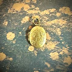 ONE tiny vintage locket in an oval shape with a floral motif. Each old stock locket has been slightly hand buffed for a warm, buttery patina. Just over a diminutive 1/2" when closed, this can possibly hold tiny photos inside. Each is unique in patina and small imperfections. COLOR: yellow brass SIZE: just over 1/2" tall and 3/8" wide when closed CONDITION: vintage old stock ONE TINY LOCKET This oval-shaped charm adorned with a delicate foor encapsulates timeless beauty and sentimental charm in i Antique Brass Locket Necklace With Charms, Vintage Oval Link Jewelry With Charms, Vintage Yellow Gold Oval Pendant Locket Necklace, Vintage Yellow Gold Oval Locket Necklace, Oval Locket Necklace For Vintage Collection, Vintage Handmade Oval Locket Necklace, Antique Oval Locket Necklace, Vintage Oval Pendant Locket Necklace With Antique Finish, Handmade Vintage Oval Pendant Locket Necklace