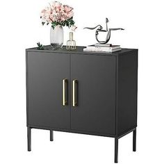 a black cabinet with two doors and some flowers on the top one door is open