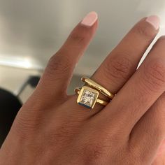 a woman's hand with a gold ring on it and a diamond in the middle