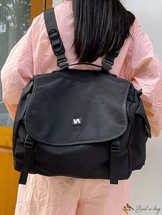 a woman with black hair is carrying a black backpack