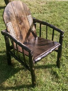 a wooden chair sitting on top of a lush green field