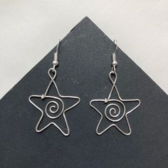 a pair of earrings with spirals and star design