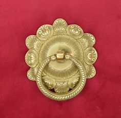 an ornate brass door handle on a red velvet background