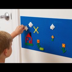 a young boy is playing with legos on the wall