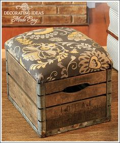 an old wooden box with a floral pattern on it sitting on the floor next to a chair