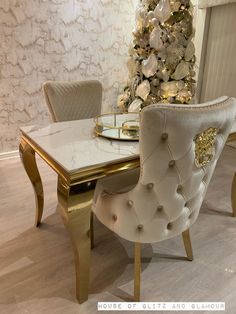 a dining room table with chairs and a christmas tree in the background