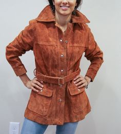 "This is an awesome vintage 70s jacket.  Features an attached belt and buttons, two front pockets. It is a heavy-duty coat.   This jacket will be sure to keep you warm on those chilly evenings.   In good condition with slight wear as you can see in the pics.   Order this item today! Size: Fits like a medium/Large 17\" shoulders 23\" arms 18\" waist (where the belt is) 24\" across at the bottom 27\" top to bottom length" Retro Belted Fall Outerwear, Retro Belted Outerwear For Fall, Vintage Leather Outerwear For Fall, Vintage Long Leather Jacket For Fall, Fall Outerwear With Belt Loops, Vintage Outerwear With Snap Buttons For Fall, Vintage Brown Buttoned Outerwear For Fall, Vintage Brown Outerwear With Buttons For Fall, Vintage Fall Outerwear With Snap Buttons