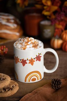 a cup of hot chocolate with marshmallows on the side and cookies next to it