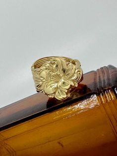 a gold ring sitting on top of a wooden table next to a white wall,