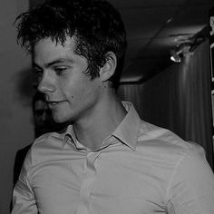 black and white photograph of a young man in a dress shirt looking at his cell phone