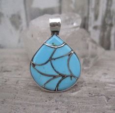 This pretty blue turquoise inlay pendant has a traditional Zuni fish scale pattern.  It is approximately 1 1/4" in length from the top of the bail to the bottom of the pendant.  It's smaller size and high shine polish gives this pendant a more contemporary feel while at the same time maintaining a Native American feel due to the traditional fish scale pattern.  Not stamped sterling though it tests as sterling.  Hallmarked ELB.  If you are not satisfied with your purchase please contact me and al Unique Blue Teardrop Turquoise Necklace, Artisan Blue Turquoise Teardrop Pendant Necklace, Blue Turquoise Inlay Necklace For Gift, Blue Turquoise Teardrop Necklace Nickel Free, Southwestern Blue Teardrop Pendant Necklace, Turquoise Inlay Necklace For A Gift, Nickel-free Blue Turquoise Teardrop Necklace, Blue Teardrop Turquoise Necklace Nickel Free, Artisan Blue Teardrop Pendant Jewelry