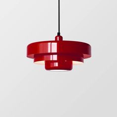 a red pendant light hanging from a ceiling