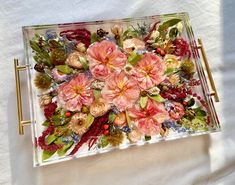 a glass tray filled with flowers on top of a white sheet