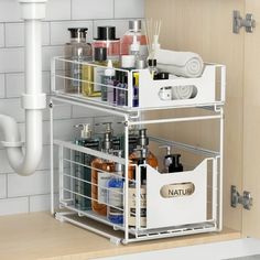 two white baskets are stacked on top of each other in the corner of a bathroom