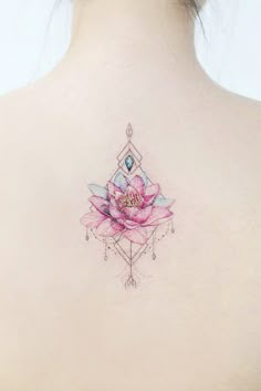 a woman's back with a pink flower tattoo on it