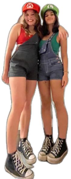 two young women standing next to each other in short shorts and baseball caps on their heads