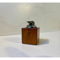 a wooden lighter holder sitting on top of a white table