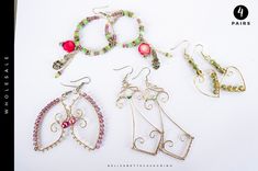 four pairs of earrings are displayed on a white surface with the words paris written below them