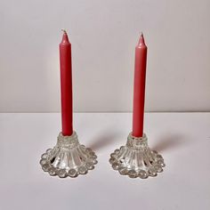 two red candles sitting next to each other on a table