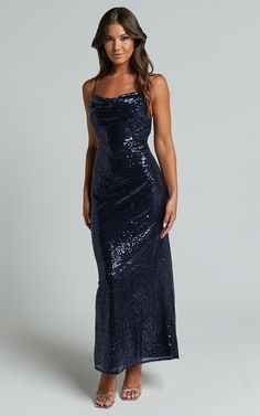 a woman wearing a long dress with sequins on the side and one shoulder