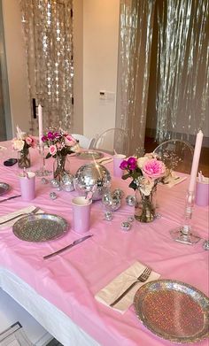 the table is set with pink and silver decorations