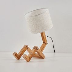 a wooden table lamp sitting on top of a white floor