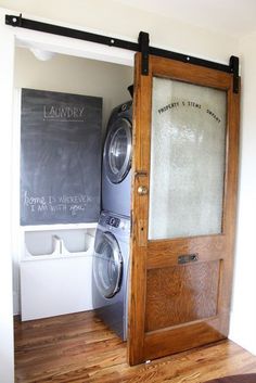 a washer and dryer sitting in front of a chalkboard on the wall