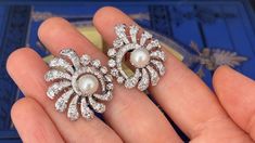 These awesome circa 1950s pierced earrings are each accented with one (1), post set, cultured saltwater Akoya pearl and thirty-nine (39), prong/bead set, old European/brilliant/single cut diamonds. The earrings measure 29.6mm X 25.7mm. The earrings are finished with hinged backs. Fine Jewelry Clip-on Diamond Earrings For Evening, Evening Clip-on Diamond Earrings Fine Jewelry, Classic Clip-on Cluster Earrings For Formal Occasions, Classic Clip-on Cluster Earrings For Formal Events, Elegant Hallmarked Diamond Clip-on Earrings, Classic Bridal Earrings With 17 Jewels For Anniversary, Vintage Diamond Clip-on Earrings, Exquisite Hallmarked Diamond Earrings For Evening, Elegant Diamond Clip-on Earrings