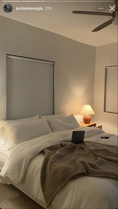 a bed with white sheets and pillows in a room