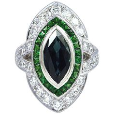 This Art deco inspired ring is centered with a bezel-set marquise shaped blue Sapphire, surrounded by Tsavorites 0.92 carat and round brilliant-cut Diamond 1.24 carats set in 18 karat White Gold. The ring is currently a size 52 (6 1/4 US) , with easy adjustment up or down. Width: 2.0 cm Length: 2.6 cm Ring Size: 52 "We first opened doors in 1980 when it was then situated in the vicinity of the Victory Monument; a small and modest storefront with a couple of counters. From its humble beginnings t Luxury Green Marquise Diamond Ring, Marquise Emerald Ring With Center Stone, Marquise Emerald Ring For Formal Occasions, Green Marquise Brilliant Cut Rings, Green Marquise Diamond Ring, Marquise Sapphire Ring With Brilliant Cut, Art Deco Marquise Diamond Ring With Center Stone, Green Marquise Emerald Ring With Accent Stones, Radiant Diamond Rings