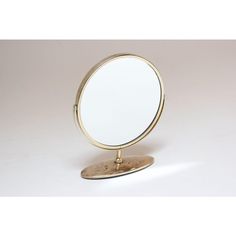 a round mirror sitting on top of a wooden stand